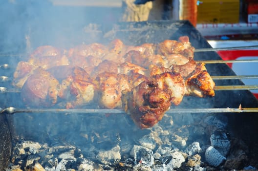 Meat is fried on skewers over charcoal on the grill