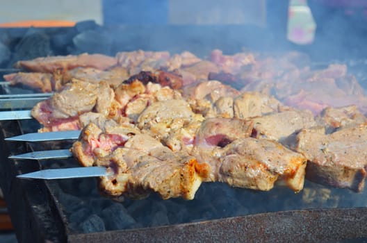 Meat is fried on skewers over charcoal on the grill