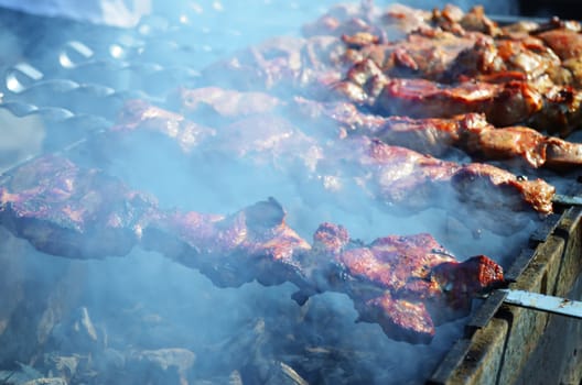 Meat is fried on skewers over charcoal on the grill