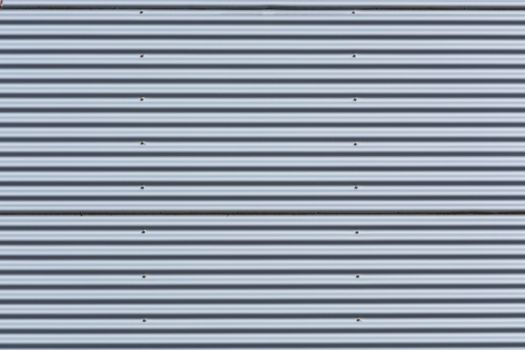 Silver-colored metal wall corrugated sheet metal background.
