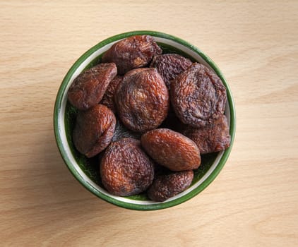 Dried apricots in an oriental bowl on a table
