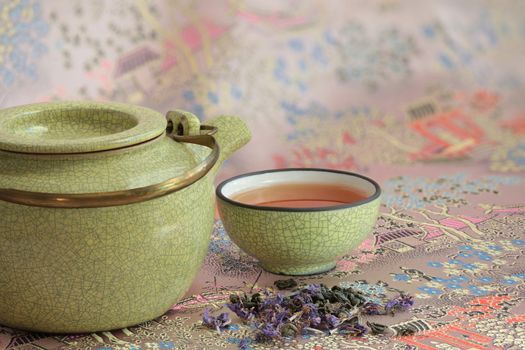 Kettle cup with tea  background of traditional eastern pattern with pagodas