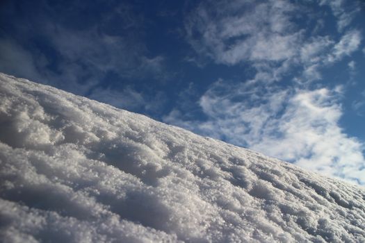 white snow mountain slope against blue sky low angle view