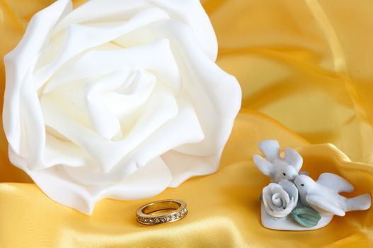 flowers, wedding rings and weddings favors on colour background