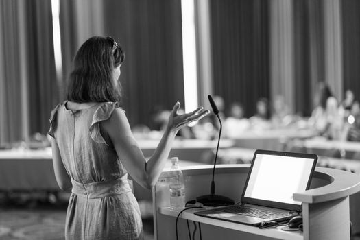 Female speaker at Business Conference and Presentation. Audience at the conference hall. Business and Entrepreneurship. Business woman. Black and white.