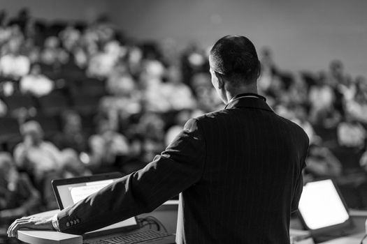 Speaker giving a talk on corporate Business Conference. Audience at the conference hall. Business and Entrepreneurship event. Black and white image.