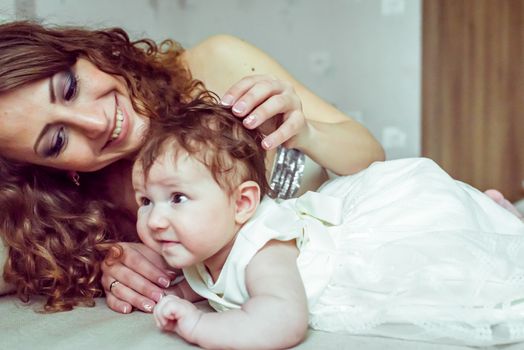 naked baby with mother lying on a white soft blanket