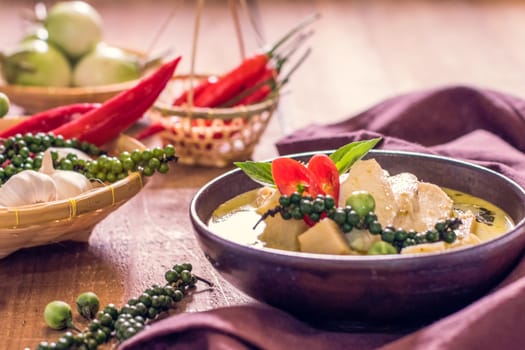 Chicken mussaman curry in bowl vegetables on wooden background.