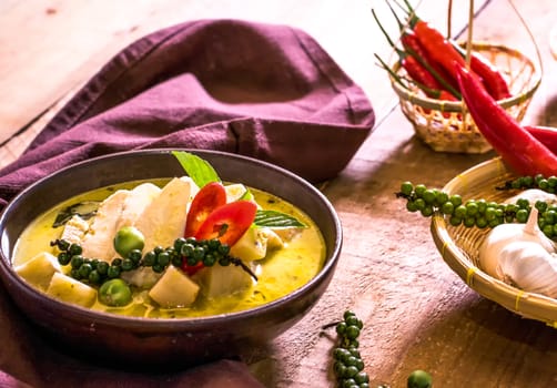 Chicken mussaman curry in bowl vegetables on wooden background.