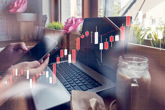 Businessman is working with his computer in coffee shop with stock chart and data overlay