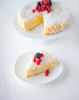 A piece of Homemade coconut cake on a white plate.