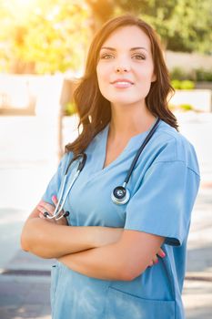 Portrait of Young Adult Female Doctor or Nurse Wearing Scrubs and Stethoscope Outside.