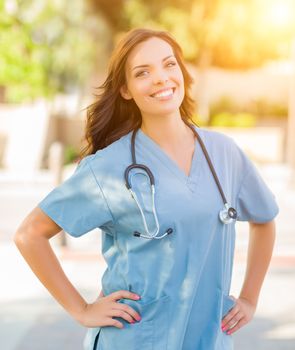 Portrait of Young Adult Female Doctor or Nurse Wearing Scrubs and Stethoscope Outside.
