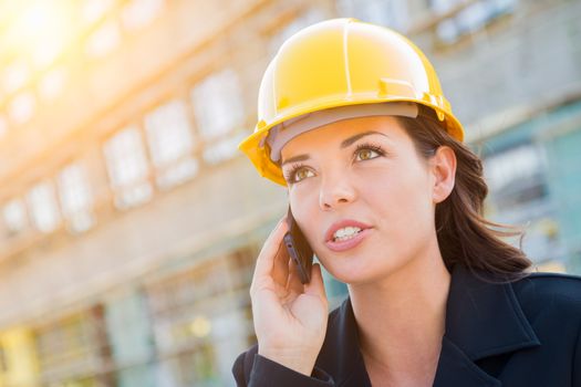 Young Professional Female Contractor Wearing Hard Hat at Construction Site Using Cell Phone.