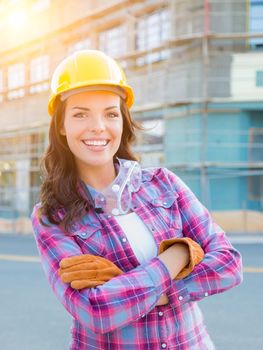 Portrait of Young Female Construction Worker Wearing Gloves, Hard Hat and Protective Goggles at Construction Site.