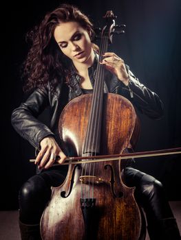 Photo of a beautiful female musician playing a cello.