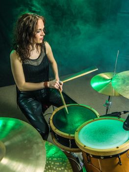 Photo of a beautiful woman playing her drum set on stage.