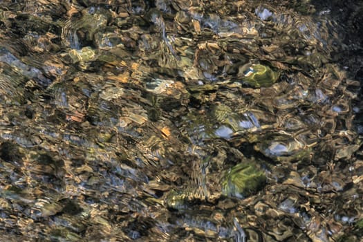 

Natural colorful stones on a lake bottom, outdoors.
