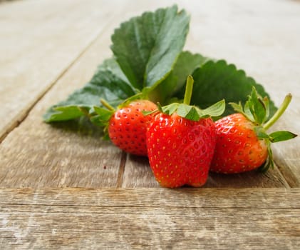 Strawberries from the garden's collection, put on a wooden table.