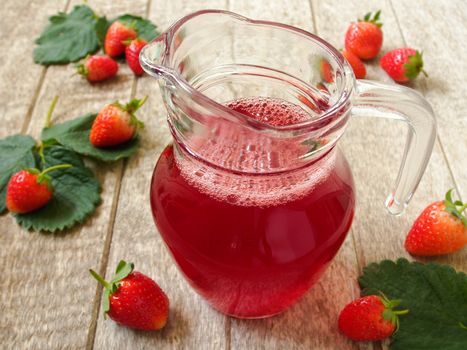 Strawberry Juice In jug on wood background