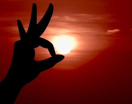 Ok hand sign silhouette. On sunset background.