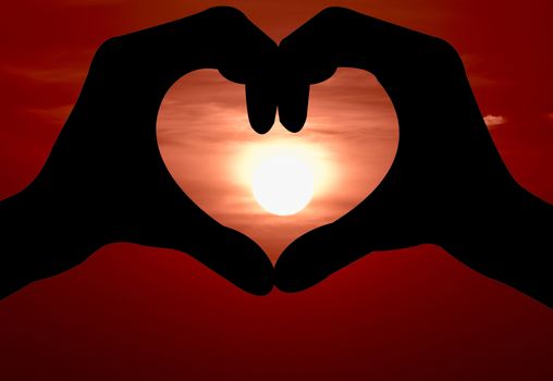 heart shape  symbol made of human  hand ,background sunset