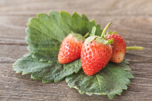 Strawberry with leaves On the wooden floor