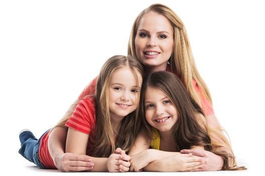 Mother and daughters lying on the floor isolated on white background