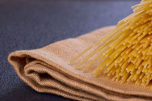 uncooked pasta on a cloth on a black background