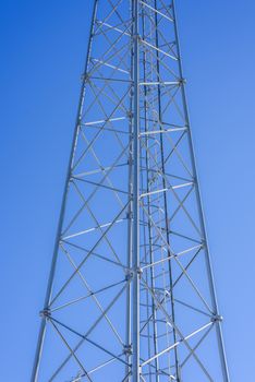 Steel tower with ladder inside against a blue sky.