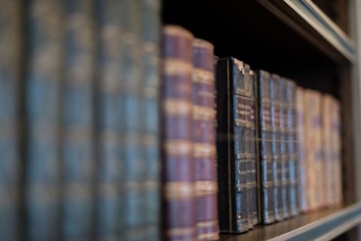 Old books on a wooden shelf.