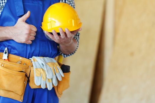 Worker in hardhat and tool belt at construction site