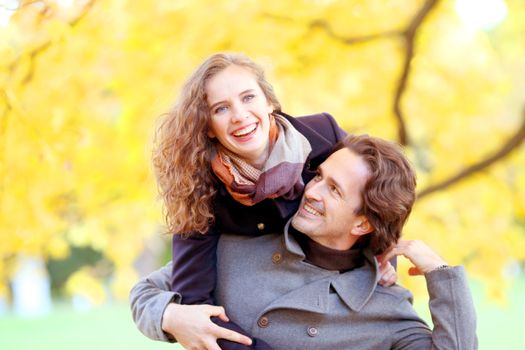 Smiling couple having fun in autumn park