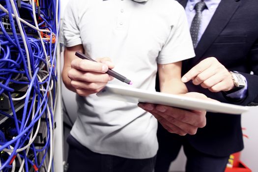 Engeneer and business man in network server room with digital tablet