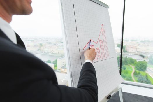 Business man pointing at financial graph showing successful growth