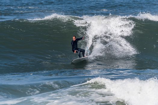 Surfer in action on the ocean waves on a sunny day.