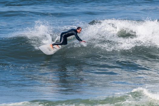 Surfer in action on the ocean waves on a sunny day.