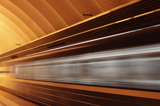 Subway platform with moving fast train