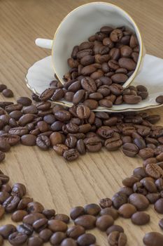 Morning heart. Heart shape made from coffee beans and a cup of coffee with beans.