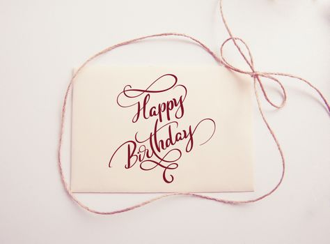 sheet of paper with bow and text Happy Birthday. Calligraphy lettering. Greating card.