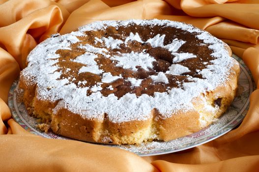 an orange homemade cake on fabric background