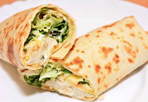 Tortilla wraps with chicken nuggets, fresh vegetable and salad.