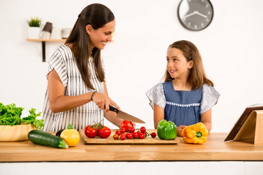 Shot of a mother and daughter having fun in the kitchen