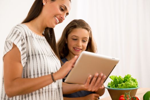 Shot of a mother and daughter having fun in the kitchen