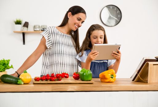 Shot of a mother and daughter having fun in the kitchen