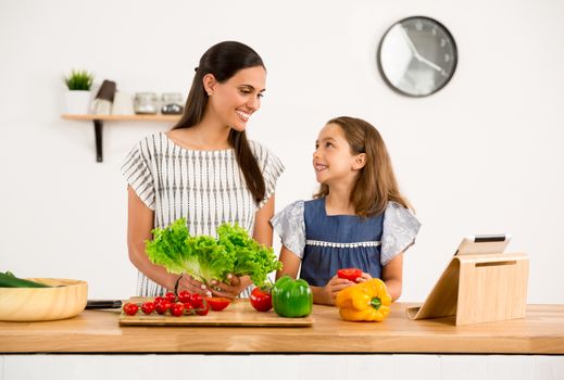 Shot of a mother and daughter having fun in the kitchen