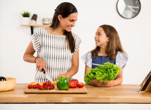 Shot of a mother and daughter having fun in the kitchen