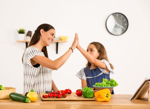 Shot of a mother and daughter having fun in the kitchen