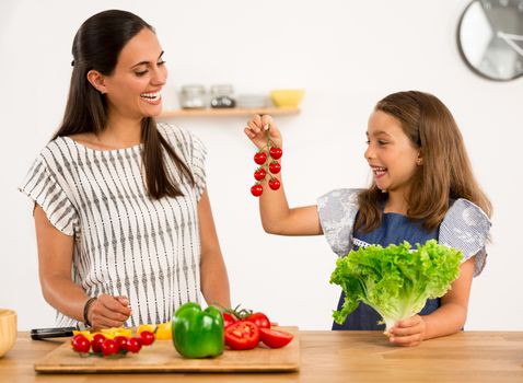 Shot of a mother and daughter having fun in the kitchen