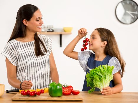 Shot of a mother and daughter having fun in the kitchen